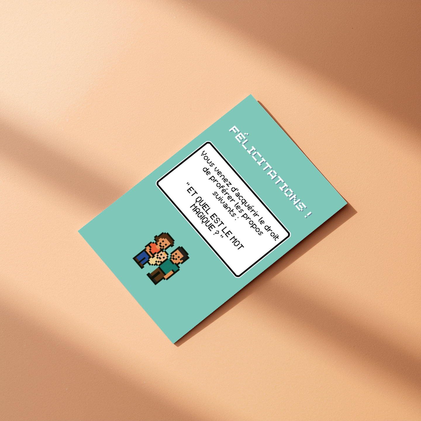 Carte de félicitations pour naissance style jeu vidéo rétro posée à plat sur une surface couleur pêche.